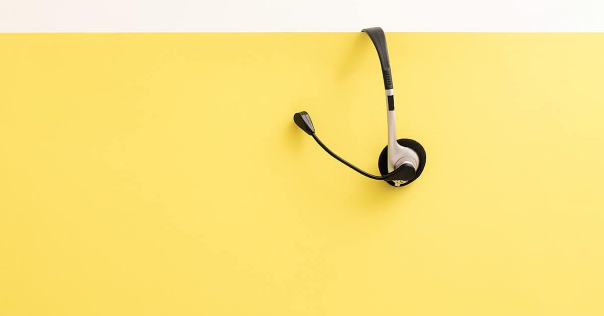 softphone hanging on yellow wall cubicle